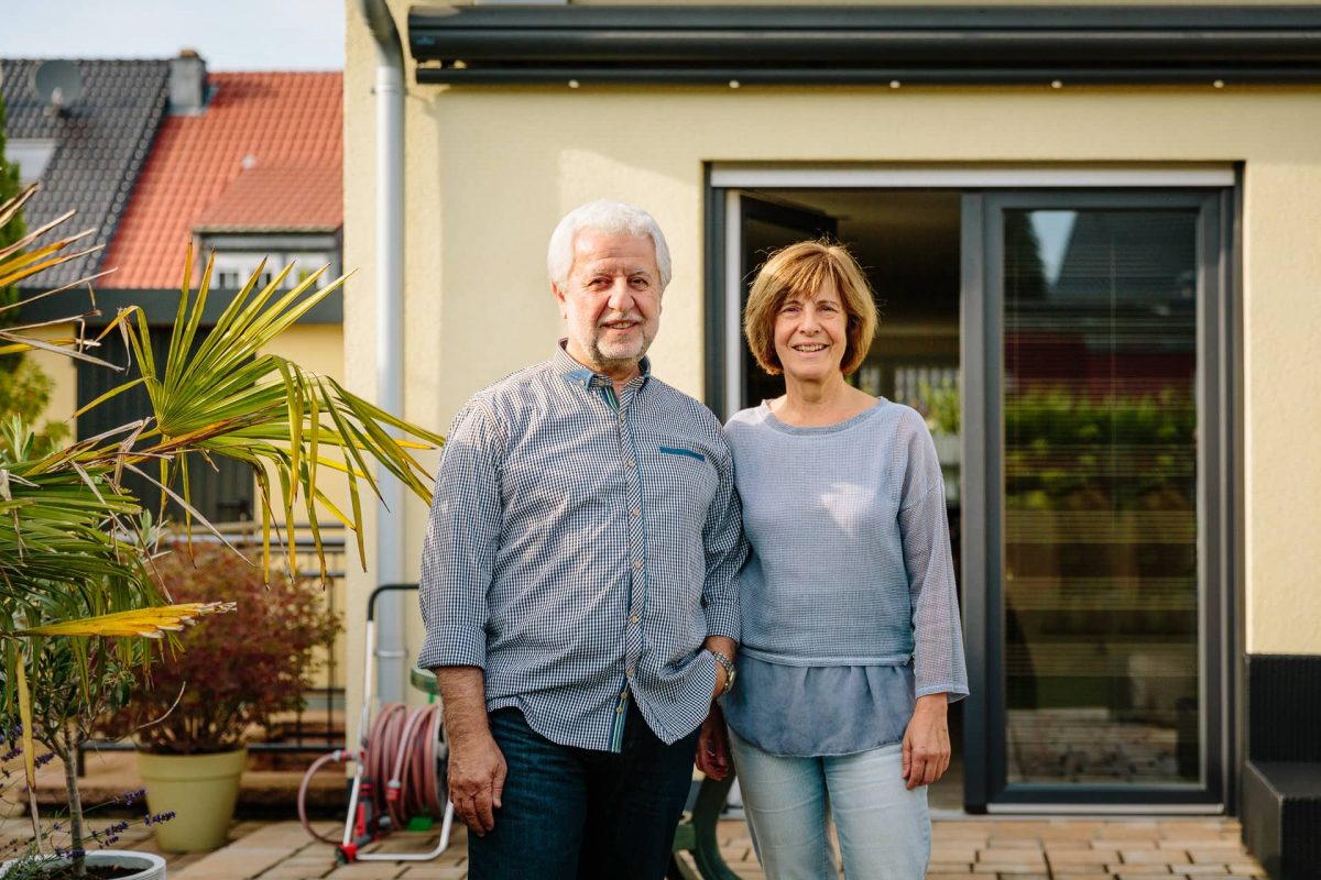 Kundenportrait mit Photovoltaikanlage im Hintergrund