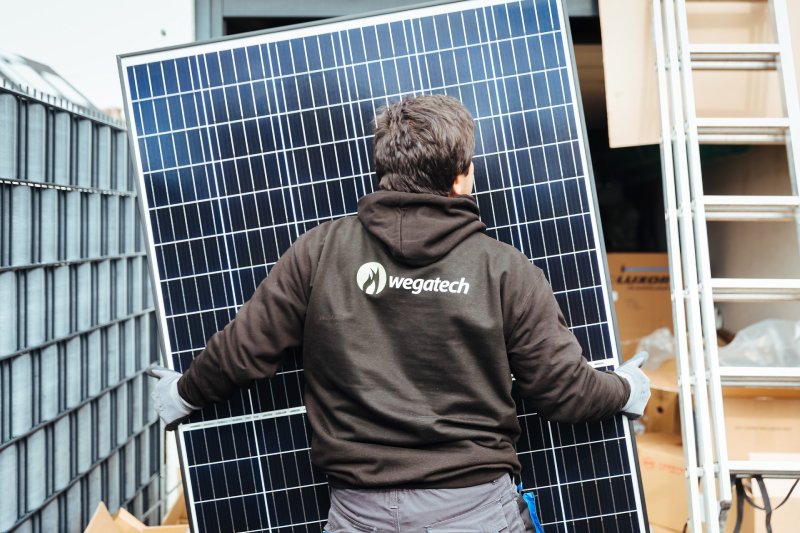 Laptop_Hand Wegatech Solarteur trägt Photovoltaikmodul