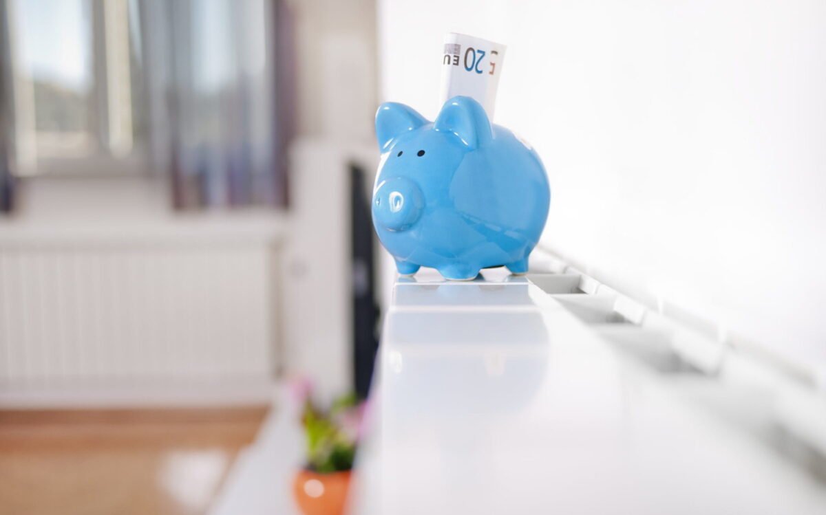 Sparschwein mit Geldscheinen auf Heizung