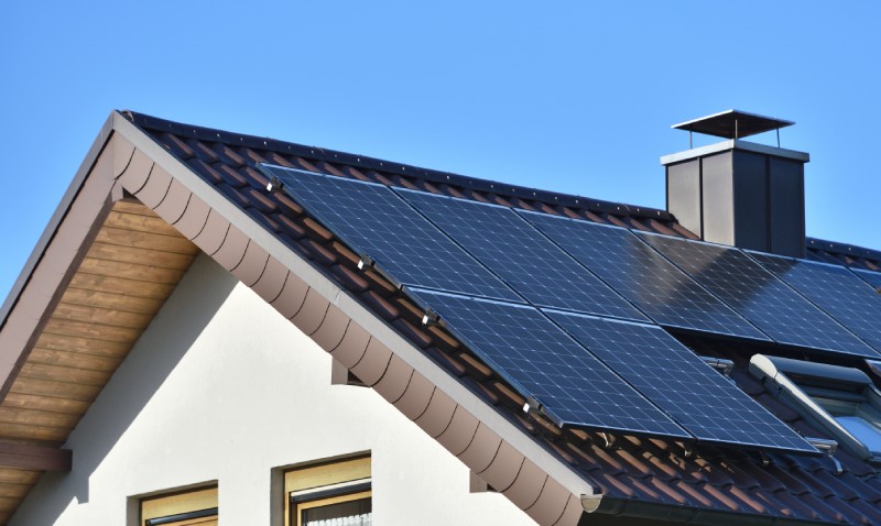 Solaranlage auf Hausdach vor blauem Himmel