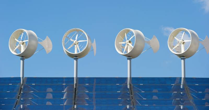 Kleine Windräder mit Solaranlage auf einem Dach