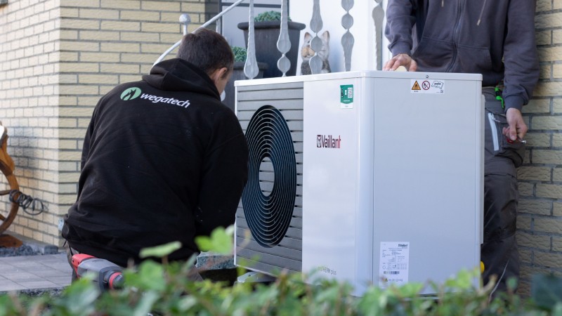 Wegatech Mitarbeiter bei der Installation einer Vaillant Wärmepumpe vor Einfamilienhaus