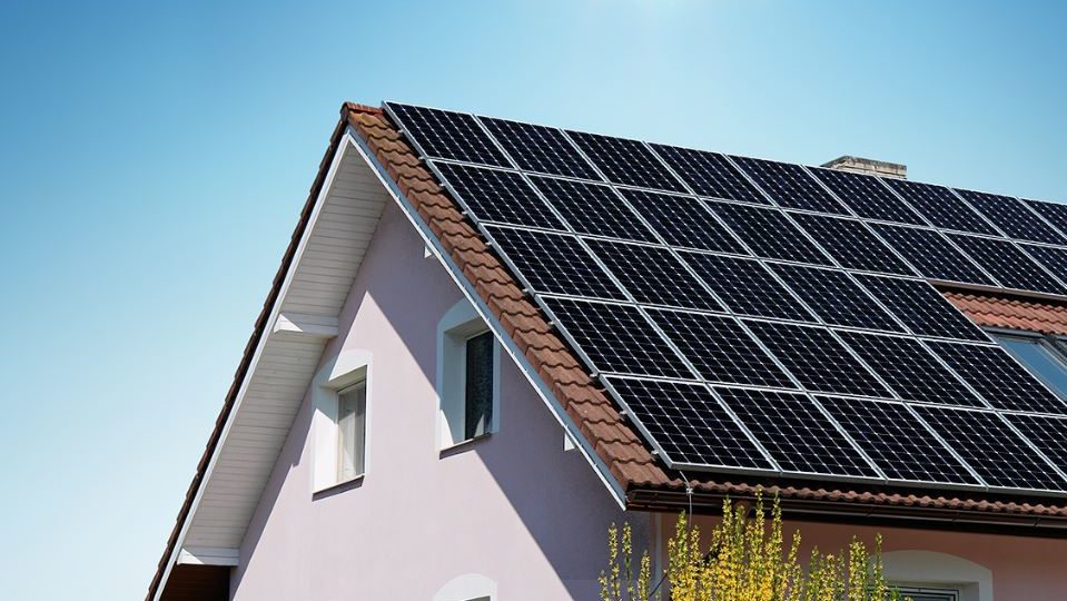 Haus mit Photovoltaik vor blauem Himmel