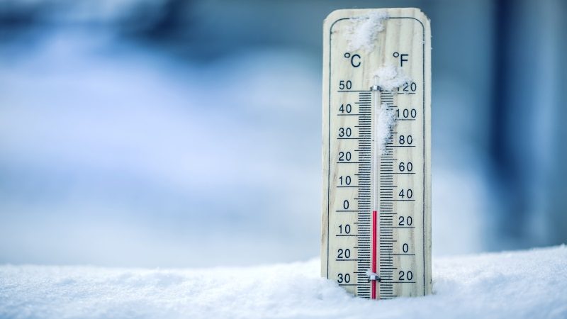 Kaeltemittel Thermometer on snow shows low temperatures - zero. Low temperatures in degrees Celsius and fahrenheit. Cold winter weather - zero celsius thirty two farenheit.